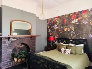 a bedroom with a brick fireplace with a mural at Forrest House Victor Harbor in Victor Harbor