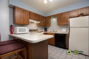 a kitchen with wooden cabinets and a white refrigerator at Senedo Springs Duplex #101A in Basye