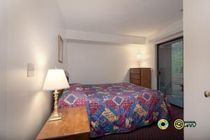 a bedroom with a bed and a table with a lamp at Senedo Springs Duplex #101A in Basye