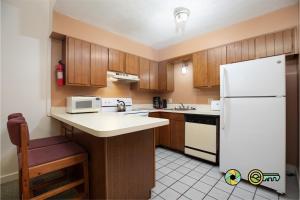 a kitchen with wooden cabinets and a white refrigerator at Senedo Springs Duplex #97A in Basye