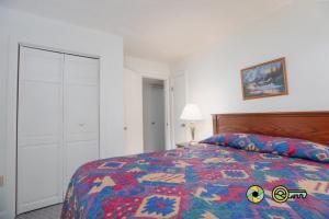 a bedroom with a bed with a colorful quilt at Senedo Springs Duplex #97A in Basye +24 photos