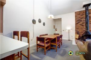 a dining room with a table and chairs and a fireplace at Senedo Springs Duplex #97B in Basye