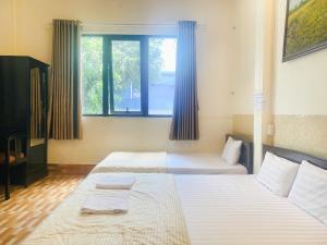 a bedroom with two beds and a window at NAM ĐÔ HOTEL Chợ Cổ Bến Ninh Kiều in Can Tho