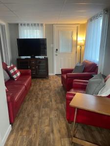 a living room with red couches and a flat screen tv at Lakeview 12B: Casa Uno Condo in Basye
