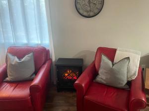 two red chairs with pillows next to a fire place at Lakeview 12B: Casa Uno Condo in Basye