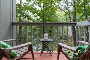 a patio with two chairs and a table on a deck at Lakeview 85B: Treehouse Mountain in Basye