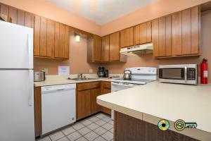 a kitchen with white appliances and wooden cabinets at Senedo Springs Duplex #98B in Basye
