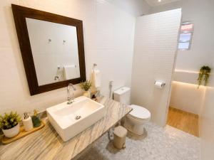 a bathroom with a sink and a toilet and a mirror at Pousada Mojomar Buzios in Búzios +16 photos
