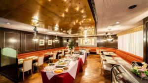 a dining room with tables and chairs in a restaurant at Hotel Resorpia Atami in Atami
