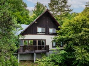 a house with a deck in the woods at AZUMINO KOGEN Resort in Azumino