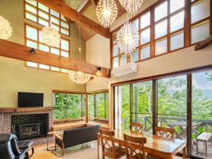a living room with a table and chairs and a fireplace at AZUMINO KOGEN Resort in Azumino