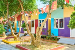 a colorful house with trees in front of it at Bugalow Tiên Sa Cô Tô in Nam Cap +1 photo