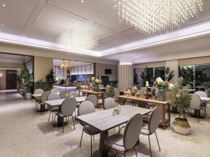 a restaurant with tables and chairs and a chandelier at Mercure Lanzhou Downtown in Lanzhou
