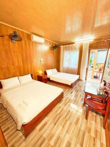a bedroom with a large bed and a table at Bugalow Tiên Sa Cô Tô in Nam Cap