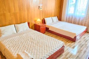 a small room with two beds and a window at Bugalow Tiên Sa Cô Tô in Nam Cap