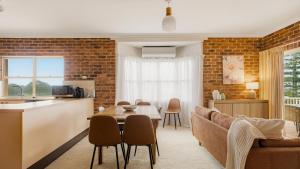 a kitchen and living room with a couch and a table at North Street Panorama in Urunga
