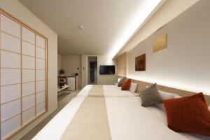 a hotel room with two beds and a television at はく HIROSHIMA Station HOTEL in Hiroshima +29 photos