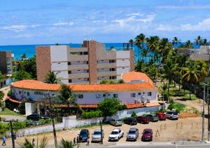 a large building with cars parked in a parking lot at Mandakaru Residence Flat da Isa 01 in Porto De Galinhas