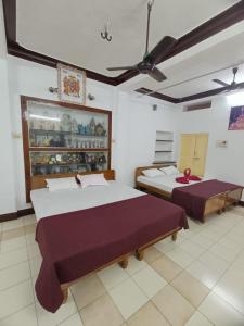 a bedroom with two beds in a room at Adb's Kuzhlam Traditional Homestay & Rooms in Tiruchirappalli