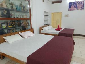 a room with two beds in a room at Adb's Kuzhlam Traditional Homestay & Rooms in Tiruchirappalli