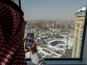 a person holding a cell phone in front of a window at Swissotel Al Maqam Makkah in Mecca +226 photos