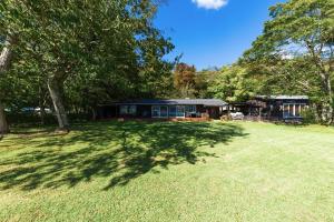 a large yard with a house with a tree at marinoe organic resort - Health and Stay - A Private Lakeside Villa at Lake Yamanaka, Blessed by the Spirit of Mount Fuji in Yamanakako
