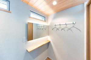 a bathroom with white walls and wooden ceilings at marinoe organic resort - Health and Stay - A Private Lakeside Villa at Lake Yamanaka, Blessed by the Spirit of Mount Fuji in Yamanakako
