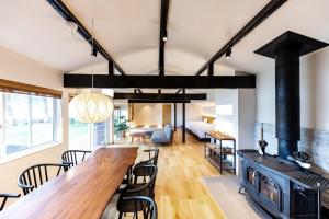 a kitchen and living room with a stove and a table at marinoe organic resort - Health and Stay - A Private Lakeside Villa at Lake Yamanaka, Blessed by the Spirit of Mount Fuji in Yamanakako +86 photos