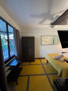 a room with a bed and a desk and a window at Casa del Sol in Tamarindo
