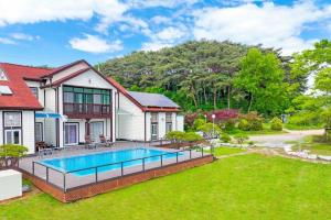 a house with a swimming pool in a yard at Anmyeondo Chingunae Pension in Taean