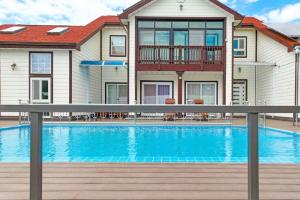 a house with a swimming pool in front of a house at Anmyeondo Chingunae Pension in Taean