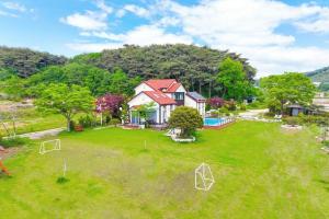 an aerial view of a house with a large yard at Anmyeondo Chingunae Pension in Taean +11 photos
