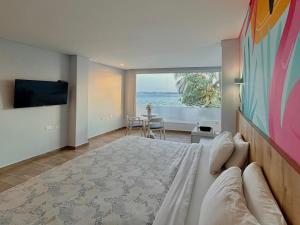 a bedroom with a bed with a view of the ocean at Hotel Caribbean Cartagena in Cartagena de Indias
