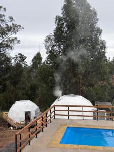 two tents on a deck next to a swimming pool at APPA Glamping Domo 2 Jacuzzi privado in El Quisco
