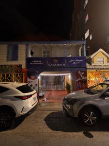 two cars parked in front of a building at night at Chill room front sea in Philipsburg