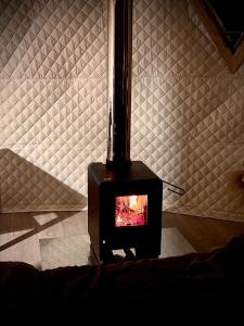 a black stove in a room with a wall at APPA Glamping Domo 2 Jacuzzi privado in El Quisco