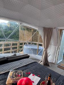 a tent with a bed and a table with wine glasses at APPA Glamping Domo 2 Jacuzzi privado in El Quisco