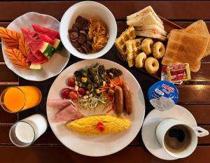 a table with plates of breakfast foods and coffee at Woraburi Sukhumvit Hotel in Bangkok