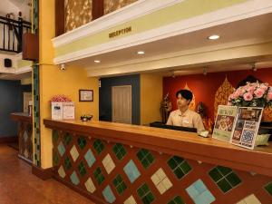 a man behind the counter of a restaurant at Woraburi Sukhumvit Hotel in Bangkok