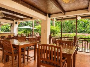 a restaurant with wooden tables and chairs and windows at Woraburi Sukhumvit Hotel in Bangkok