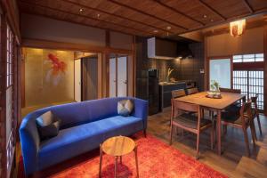 ein Wohnzimmer mit einem blauen Sofa und einem Tisch in der Unterkunft Hikoso-machi Kin no Ma in Kanazawa