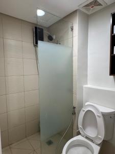 a bathroom with a white toilet and a shower at PY Suites Tagaytay in Tagaytay +11 photos