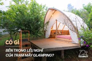 a tent with a bed on a wooden deck at Trạm Mây Glamping in Da Lat