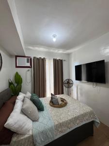 a bedroom with a bed and a flat screen tv at PY Suites Tagaytay in Tagaytay