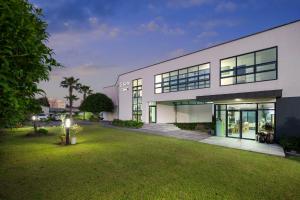 a large white building with a lawn in front of it at Dorami Pension in Seogwipo