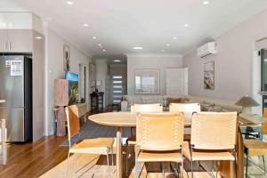a kitchen and dining room with a table and chairs at Sunkissed & Studio in Vincentia