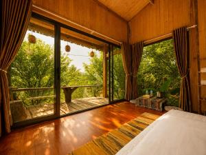 a bedroom with a bed and a large window at Zenna Lake Retreat in Tien Xuan