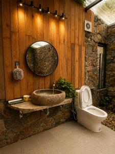 a bathroom with a sink and a toilet and a mirror at Zenna Lake Retreat in Tien Xuan +34 photos