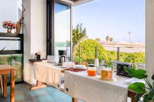 a room with a table with food on a balcony at Dorami Pension in Seogwipo