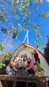 a group of people sitting on top of a sign at Trạm Mây Glamping in Da Lat